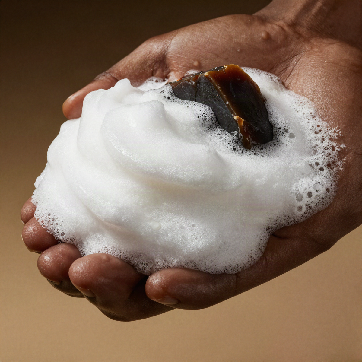 Rich lather from African black soap in a cupped hand